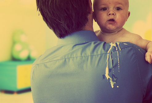 Bebê que acabou de golfar em seu pai.